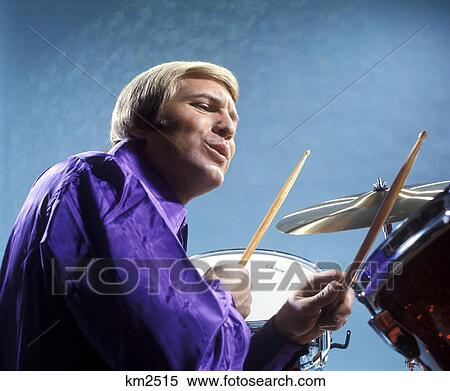 1970s man playing drums wearing purple shirt View Large Photo Image Stock Photography - 1970s man playing drums wearing purple shirt. Fotosearch
