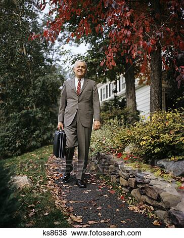 1970s mature businessman with briefcase walking autumn tree View Large Photo Image Stock Photo - 1970s mature businessman with briefcase walking autumn tree. Fotosearch