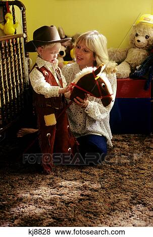 1970s mom & little boy dressed as cowboy riding a stick horse View Large Photo Image Stock Photo - 1970s mom & little boy dressed as cowboy riding a stick horse. Fotosearch
