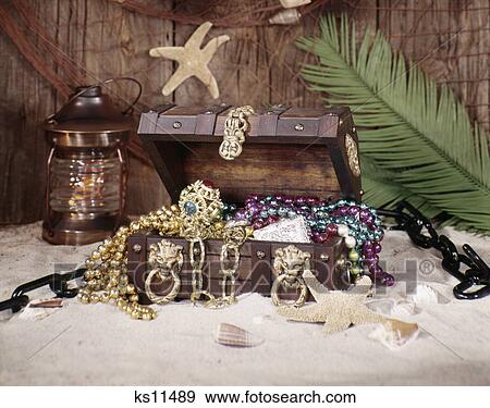 Stock Photo - 1970s nautical still life open treasure chest filled with booty pirate gold. Fotosearch