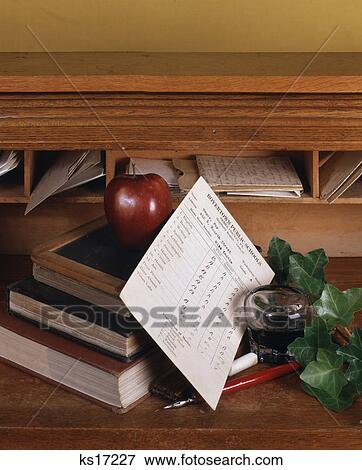 Stock Photo - 1970s nostalgic teachers desk with apple report card books pen ink. Fotosearch