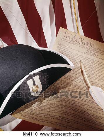 Stock Image - 1970s patriotic still life of american flag tricorn hat and constitution with quill pen. Fotosearch
