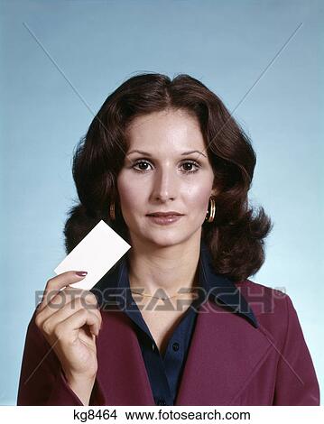 1970s portrait of brunette woman wearing suit holding blank business card View Large Photo Image Picture - 1970s portrait of brunette woman wearing suit holding blank business card. Fotosearch