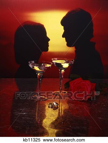 1970s portrait silhouette of couple man woman at sunset gold wedding rings wine glasses rose engagement View Large Photo Image Stock Photography - 1970s portrait silhouette of couple man woman at sunset gold wedding rings wine glasses rose engagement. Fotosearch