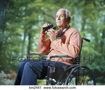 1970s senior man sitting in wheelchair outdoors using binoculars bird watching View Large Photo Image Stock Image - 1970s senior man sitting in wheelchair outdoors using binoculars bird watching. Fotosearch