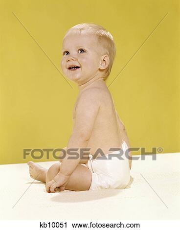 1970s smiling baby wearing diaper sitting on blanket looking over shoulder View Large Photo Image Stock Image - 1970s smiling baby wearing diaper sitting on blanket looking over shoulder. Fotosearch