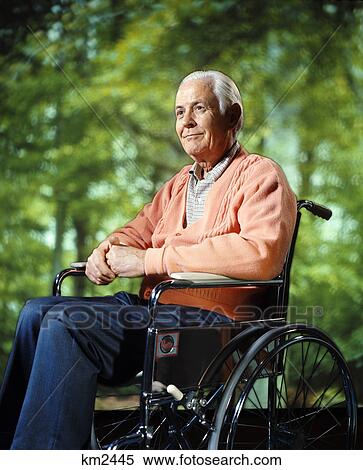 Stock Photography - 1970s smiling elderly senior man sitting wheelchair. Fotosearch