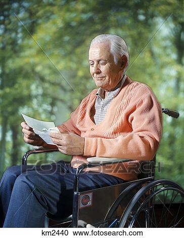 1970s smiling senior man sitting in wheelchair reading letter outdoors View Large Photo Image Stock Image - 1970s smiling senior man sitting in wheelchair reading letter outdoors. Fotosearch