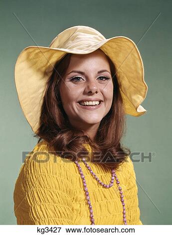 1970s smiling young woman wearing yellow floppy brim hat and blouse with pink beads View Large Photo Image Stock Photo - 1970s smiling young woman wearing yellow floppy brim hat and blouse with pink beads. Fotosearch