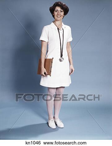 1970s standing full length portrait of woman nurse smiling wearing white uniform and stethoscope View Large Photo Image Stock Photograph - 1970s standing full length portrait of woman nurse smiling wearing white uniform and stethoscope. Fotosearch
