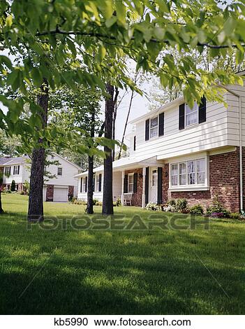 1970s suburban split level house with black shutters and brick siding View Large Photo Image Stock Image - 1970s suburban split level house with black shutters and brick siding . Fotosearch