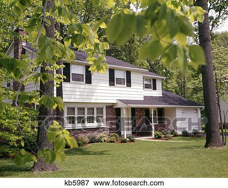 1970s suburban split level house with black shutters brick siding and landscaped lawn View Large Photo Image Stock Photo - 1970s suburban split level house with black shutters brick siding and landscaped lawn. Fotosearch