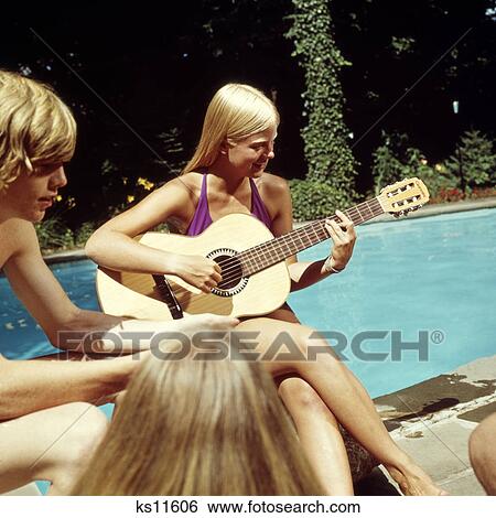 1970s teen girl playing guitar swimming pool party View Large Photo Image Stock Photograph - 1970s teen girl playing guitar swimming pool party. Fotosearch