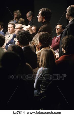 1970s television studio audience with man standing asking question View Large Photo Image Picture - 1970s television studio audience with man standing asking question. Fotosearch