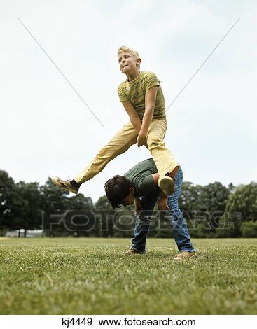 1970s two boys jumping playing leapfrog View Large Photo Image Stock Photo - 1970s two boys jumping playing leapfrog. Fotosearch