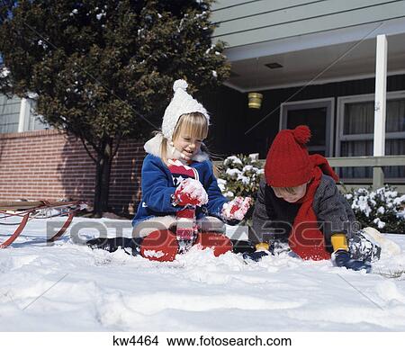 1970s two children playing in the snow with a sled View Large Photo Image Picture - 1970s two children playing in the snow with a sled. Fotosearch