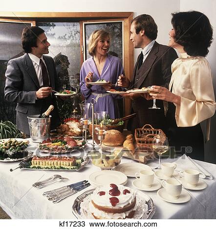 1970s two couples socializing at party buffet table View Large Photo Image Stock Image - 1970s two couples socializing at party buffet table. Fotosearch