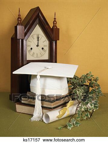 1970s white graduation mortarboard ivy diploma and book with antique clock View Large Photo Image Stock Photo - 1970s white graduation mortarboard ivy diploma and book with antique clock. Fotosearch