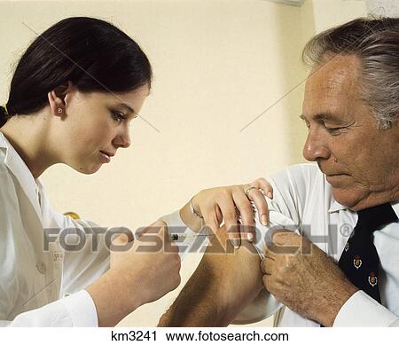 1970s woman nurse giving injection to senior man patient View Large Photo Image Stock Image - 1970s woman nurse giving injection to senior man patient. Fotosearch