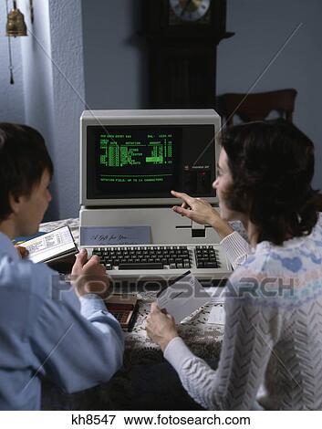 Stock Photo - 1980s couple working at apple iii 3 home computer paying bills. Fotosearch