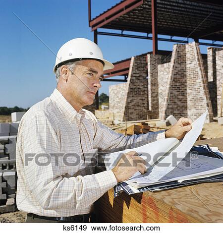 1980s man wearing construction hard hat holding blueprints View Large Photo Image Stock Photo - 1980s man wearing construction hard hat holding blueprints. Fotosearch