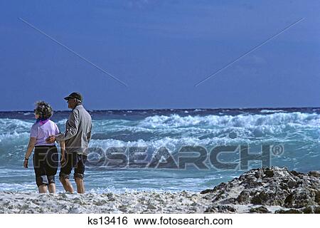 1980s mature couple walking ocean beach View Large Photo Image Stock Photograph - 1980s mature couple walking ocean beach. Fotosearch