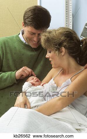 Stock Image - 1980s parents with newborn infant. Fotosearch