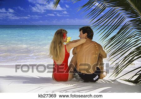 1990s couple on tropical beach with palm frond ocean and sky View Large Photo Image Stock Photo - 1990s couple on tropical beach with palm frond ocean and sky. Fotosearch
