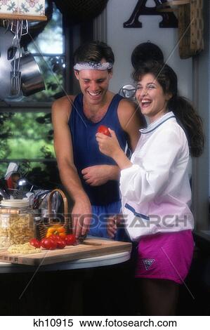 1990s laughing young couple in kitchen cutting vegetables for salad View Large Photo Image Stock Photography - 1990s laughing young couple in kitchen cutting vegetables for salad. Fotosearch