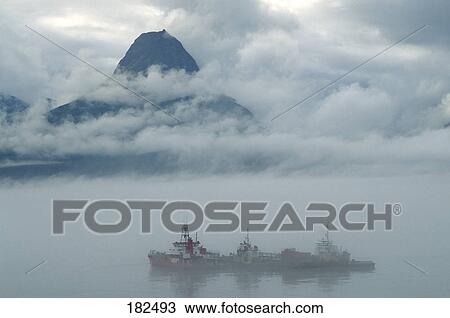 Stock Image - 3 fishing boats in fog over valdez harbor, alaska. Fotosearch