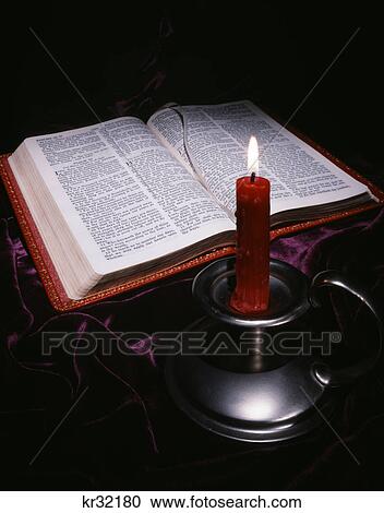 Stock Image - bible and red candle in pewter holder. Fotosearch