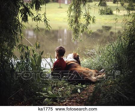 Stock Photography - boy fishing with his dog by his side. Fotosearch