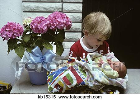 boy holding a newborn baby View Large Photo Image Stock Photography - boy holding a newborn baby. Fotosearch