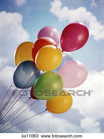 bunch of multicolored balloons in blue sky with white clouds View Large Photo Image Stock Image - bunch of multicolored balloons in blue sky with white clouds. Fotosearch