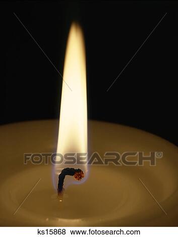 Stock Photo - close-up flame of burning candle wick. Fotosearch