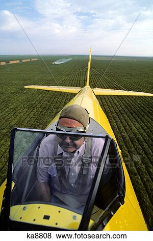 Stock Photo - close-up of pilot in cockpit of crop dusting airplane. Fotosearch