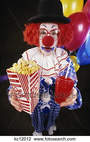 Stock Image - clown with glasses and hat holding popcorn and drink. Fotosearch