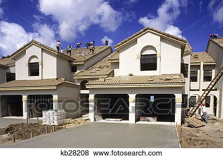 construction site workers putting tile roof on stucco townhouses View Large Photo Image Stock Photo - construction site workers putting tile roof on stucco townhouses. Fotosearch
