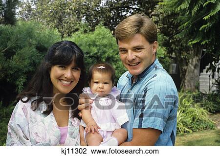 Stock Image - couple holding baby. Fotosearch