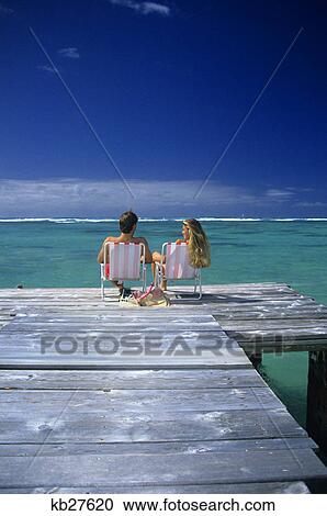 couple sitting on a pier in an ocean lagoon in the tropics View Large Photo Image Stock Image - couple sitting on a pier in an ocean lagoon in the tropics. Fotosearch