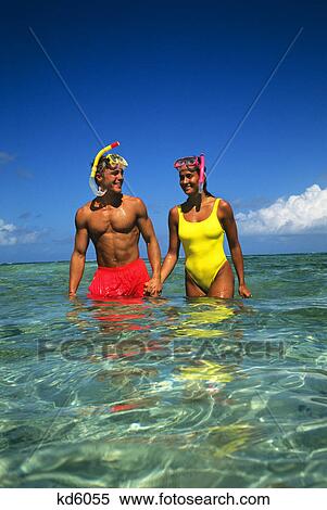 Stock Photography - couple with snorkeling masks, standing in thigh deep water tobago cays, west indies. Fotosearch