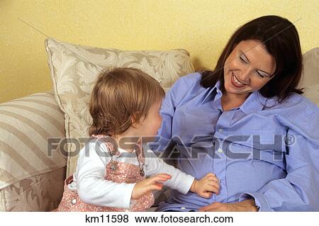 daughter touching pregnant mothers belly View Large Photo Image Stock Photo - daughter touching pregnant mothers belly. Fotosearch