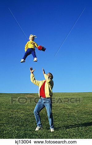 father throwing daughter up in the air View Large Photo Image Picture - father throwing daughter up in the air. Fotosearch