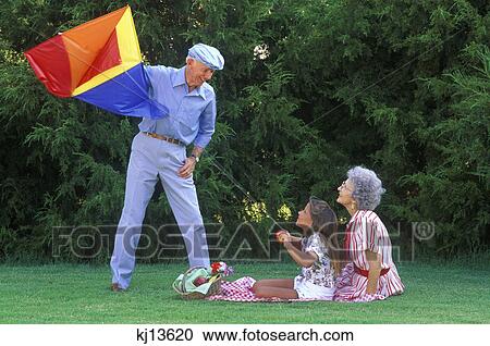 grandparents and granddaughter flying kite on picnic View Large Photo Image Stock Image - grandparents and granddaughter flying kite on picnic. Fotosearch