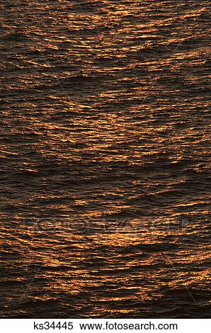 Stock Photography - high view of rising sun reflecting on ocean. Fotosearch