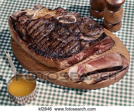 huge porterhouse steak on wooden platter 2 slices medium rare cup of drawn butter salt pepper shakers green checked cloth View Large Photo Image Stock Photograph - huge porterhouse steak on wooden platter 2 slices medium rare cup of drawn butter salt pepper shakers green checked cloth. Fotosearch