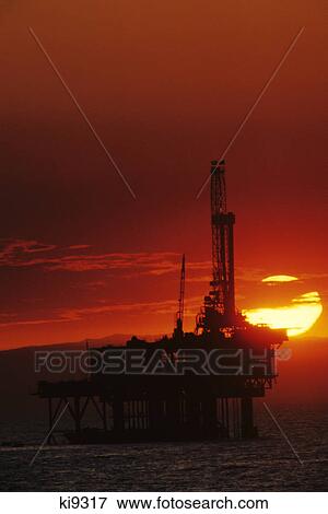 Stock Photo - offshore oil platform at sunset southern california red sky yellow sun. Fotosearch