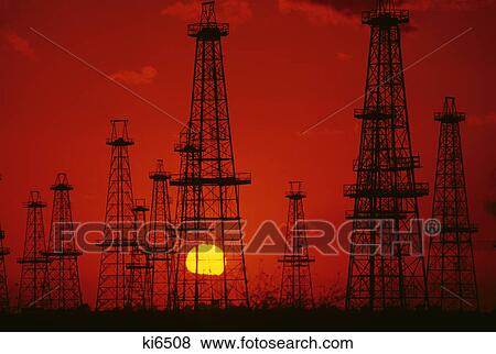 oil field derricks silhouetted against red sky and yellow sun View Large Photo Image Stock Photo - oil field derricks silhouetted against red sky and yellow sun. Fotosearch
