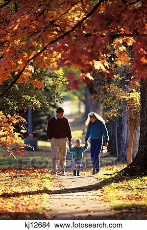 parents and son walking on sidewalk in autumn View Large Photo Image Picture - parents and son walking on sidewalk in autumn. Fotosearch