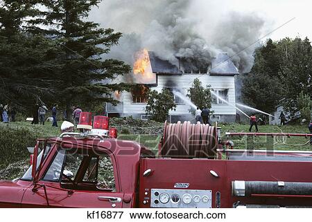 Stock Photo - rural house fire with volunteer fire truck in foreground. Fotosearch